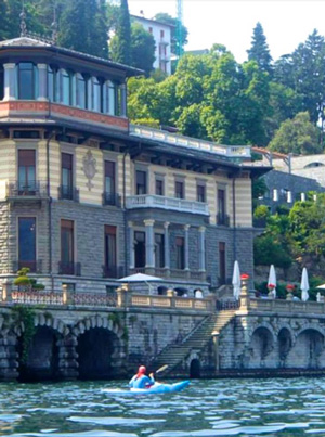 Photo of kayaker on Lake Como with a villa in the background